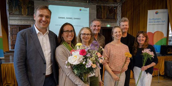 Gruppe im Saal mit Blumen